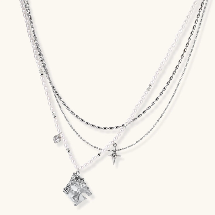 Multi-strand layered necklace set with silver chains, white pearls, star charm, heart pendant, and ornate decorative piece