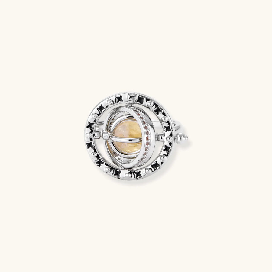 Adjustable brass ring with rotating zirconia center, surrounded by black enamel celestial stars and moon details