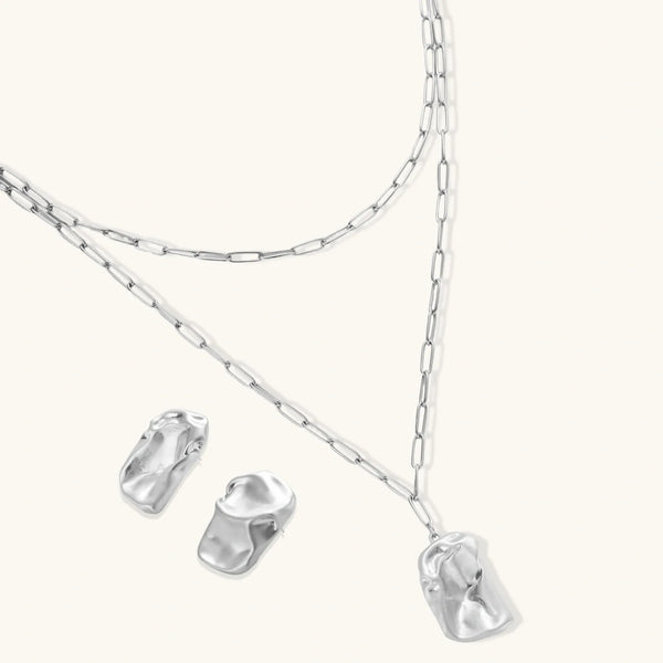 Modern textured hoop earrings and layered chain necklace with liquid metal pendant in silver and gold finishes.