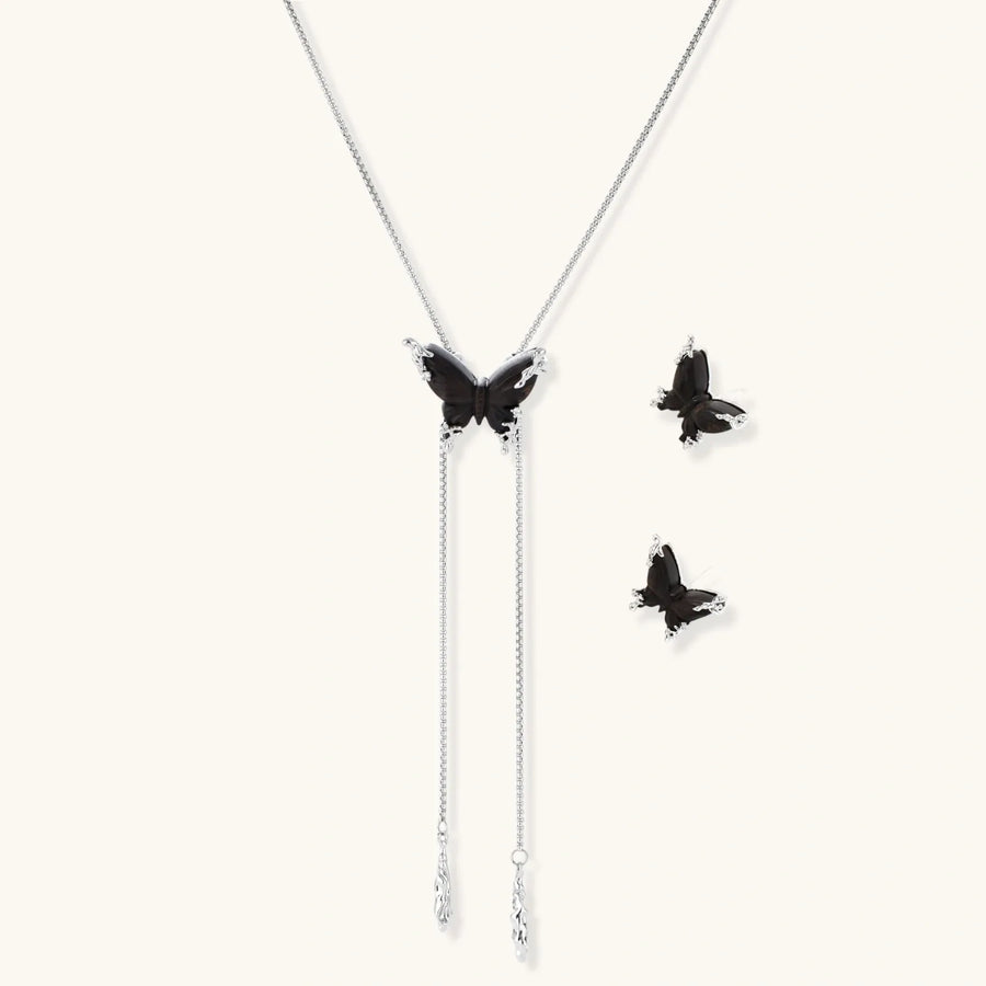 Dark wood butterfly earrings and necklace with silver chain accents on white background, showing natural grain texture.