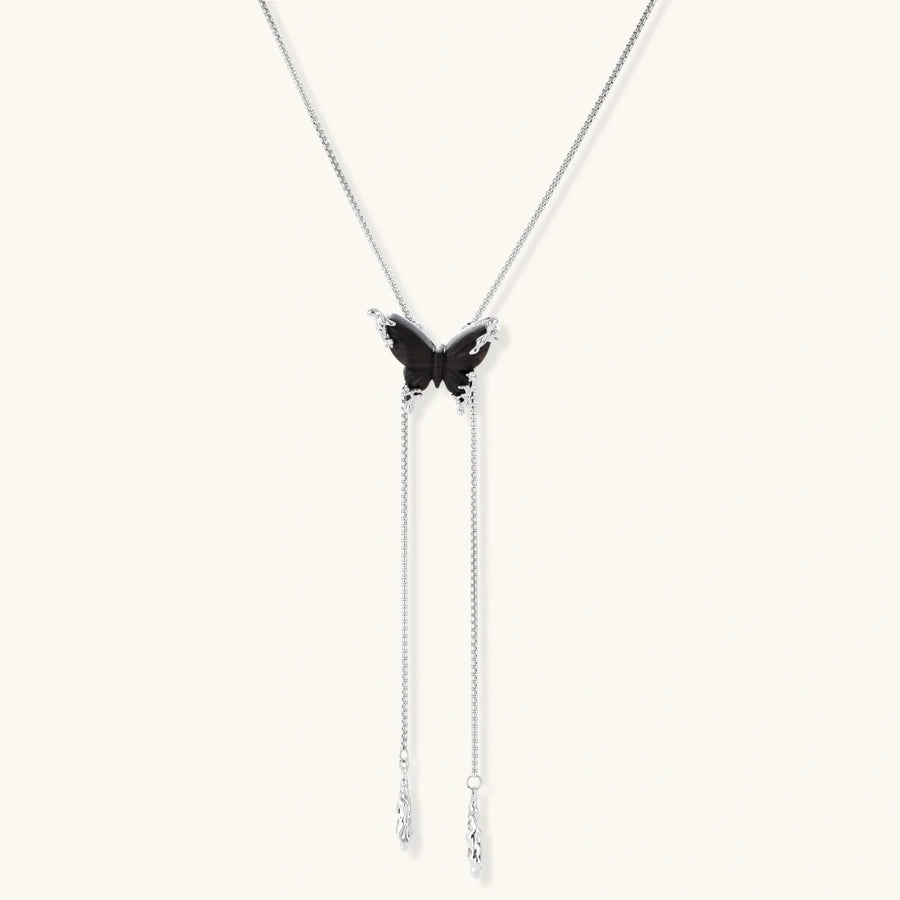 Dark wood butterfly earrings and necklace with silver chain accents on white background, showing natural grain texture.