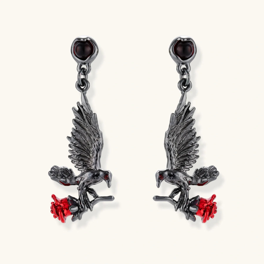Dark gunmetal jewelry set featuring detailed raven pendants carrying red enamel roses with layered pearl and chain necklaces
