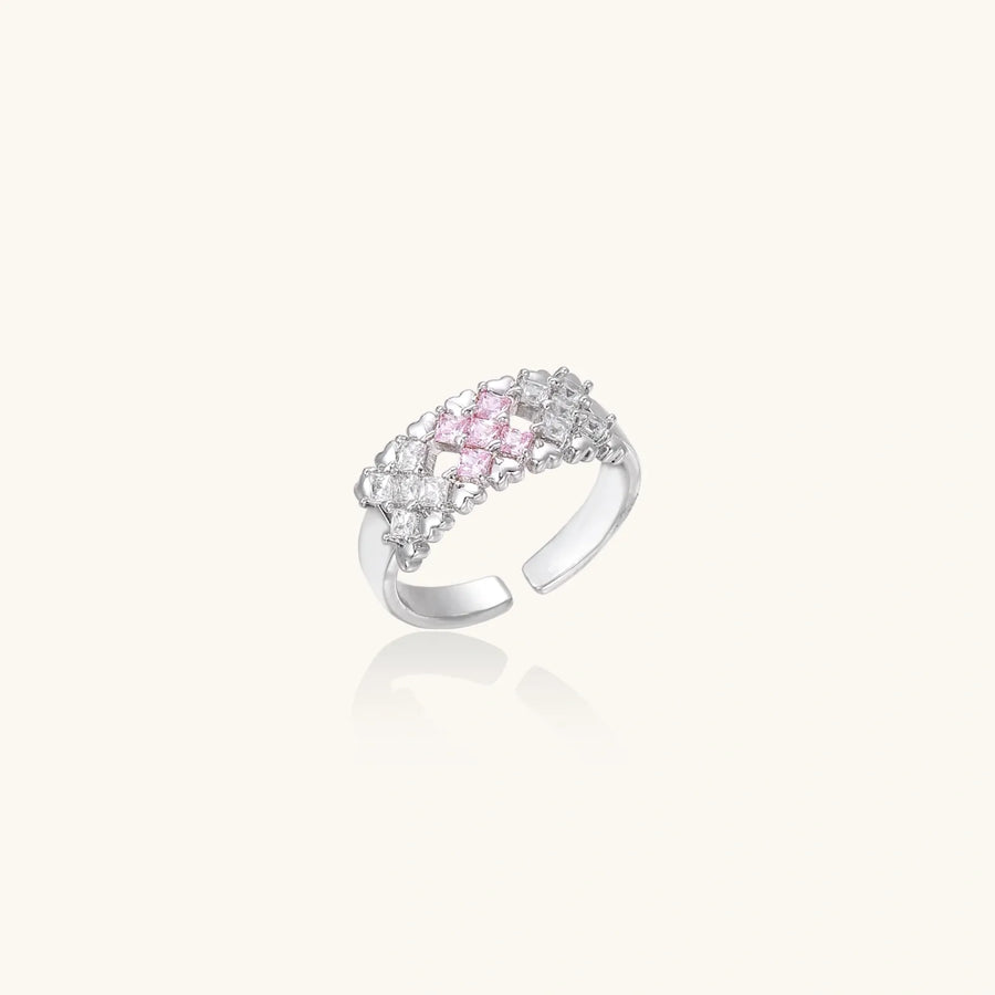 Close-up of an adjustable white gold plated ring featuring a cluster of square-cut clear and pink zirconia stones in geometric arrangement.