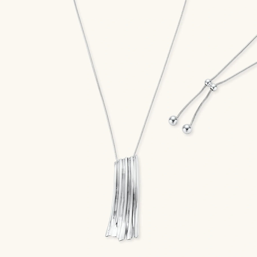 Modern silver necklace with vertical ridged pendant and adjustable chain on white background, eco-friendly zinc alloy construction.