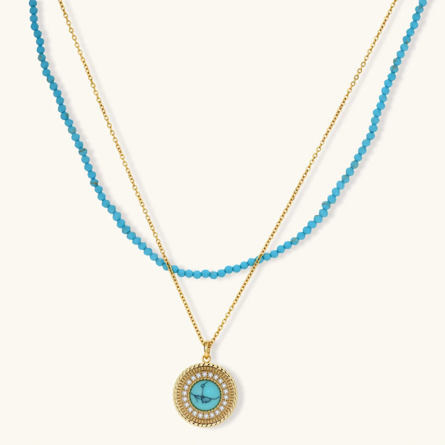Gold-plated turquoise jewelry set with circular medallion pendant, beaded necklace, and matching stud earrings on white background