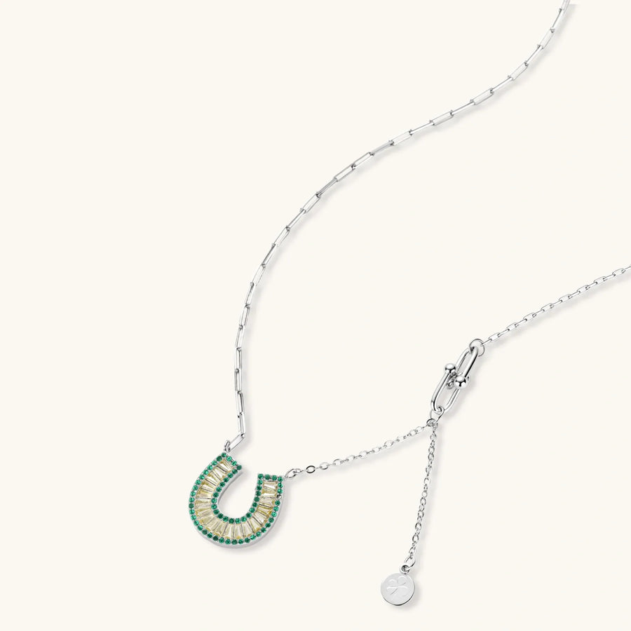 Geometric horseshoe-shaped jewelry set with radiating white zirconia center and jade-green border stones on white background.