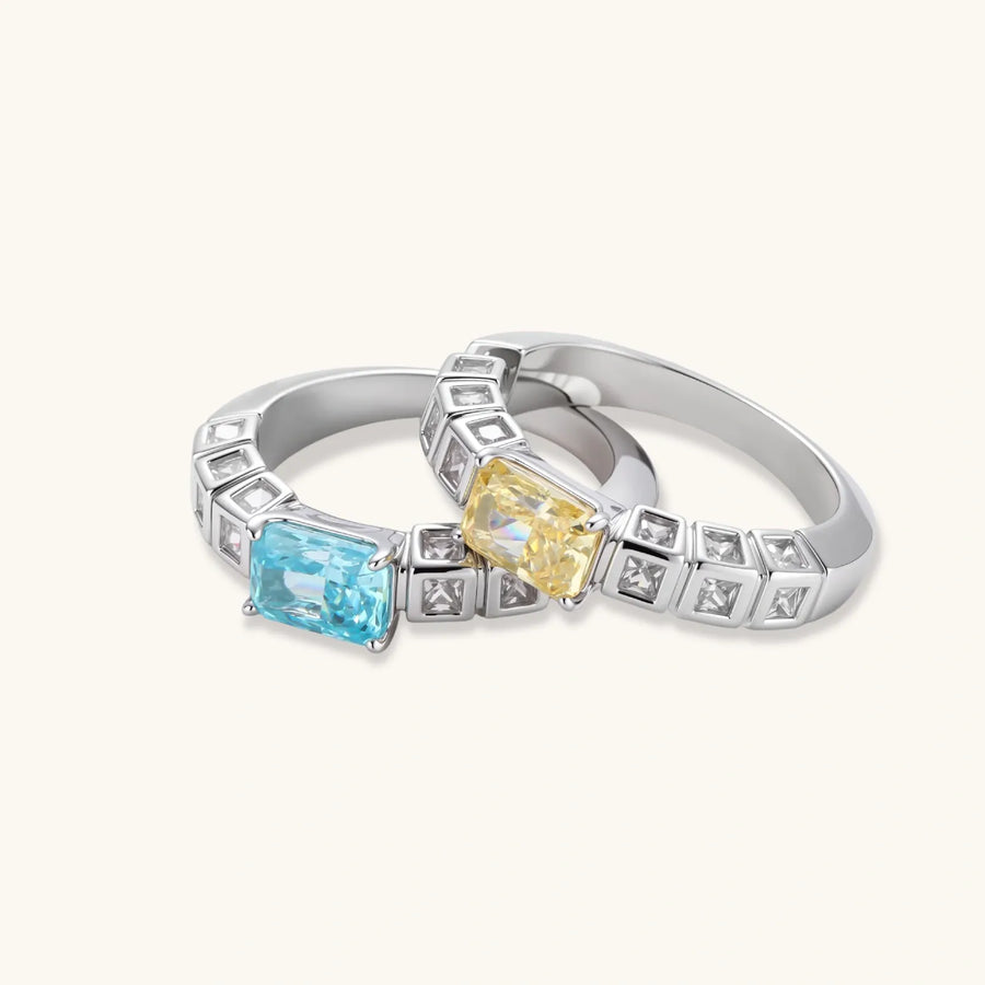 Adjustable ring with emerald-cut yellow zirconia center and clear accent stones in geometric platinum-plated setting