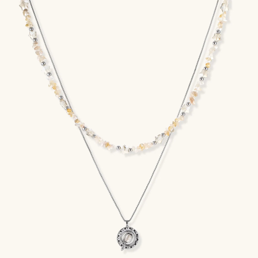 Two-layer necklace with natural stone chips and eco-brass beads, featuring a circular wrapped pendant on cream background.