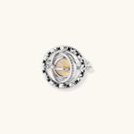 Adjustable brass ring with rotating zirconia center, surrounded by black enamel celestial stars and moon details