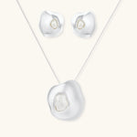 Organic curved earrings and necklace featuring baroque pearls in eco-zinc alloy settings on neutral background