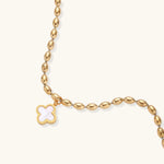 18K gold-plated oval bead chain bracelet with quatrefoil clover charm featuring mother of pearl inlay on cream background