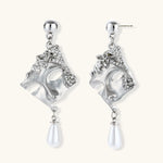 Ornate silver-toned masquerade mask jewelry set featuring rhinestone details and pearl drop earrings on white background.