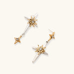 Layered silver-toned necklace set with cross pendant and gold sun charm detail, matching drop earrings on white background.