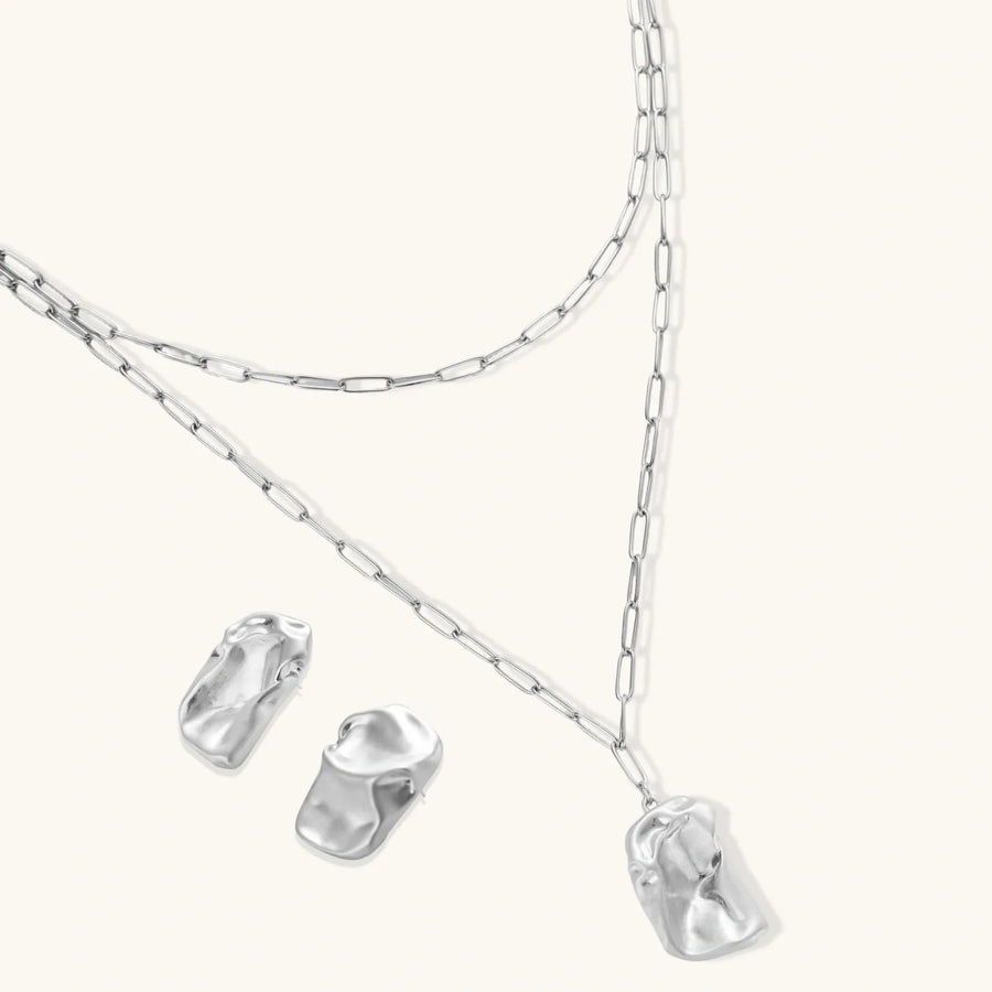 Modern textured hoop earrings and layered chain necklace with liquid metal pendant in silver and gold finishes.