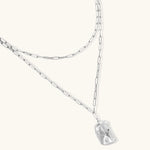 Modern textured hoop earrings and layered chain necklace with liquid metal pendant in silver and gold finishes.