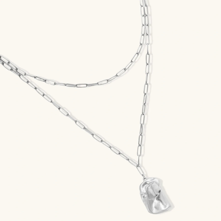 Modern textured hoop earrings and layered chain necklace with liquid metal pendant in silver and gold finishes.