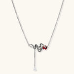 Gothic jewelry set with silver snake designs holding red enamel roses, featuring detailed leaf stems on cream background