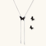 Dark wood butterfly earrings and necklace with silver chain accents on white background, showing natural grain texture.