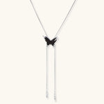 Dark wood butterfly earrings and necklace with silver chain accents on white background, showing natural grain texture.