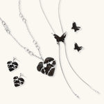 Dark wood butterfly earrings and necklace with silver chain accents on white background, showing natural grain texture.