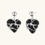 Dark ebony wood heart charms wrapped in intricate silver chains with crystal accents, shown as matching earrings and necklace set.