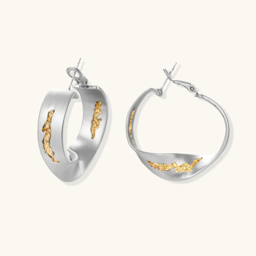 Artistic jewelry set featuring curved silver pendant with gold veining on black cord plus matching asymmetrical hoop earrings