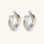 Artistic jewelry set featuring curved silver pendant with gold veining on black cord plus matching asymmetrical hoop earrings