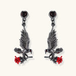 Dark gunmetal jewelry set featuring detailed raven pendants carrying red enamel roses with layered pearl and chain necklaces