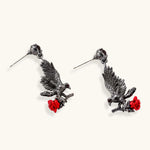 Dark gunmetal jewelry set featuring detailed raven pendants carrying red enamel roses with layered pearl and chain necklaces