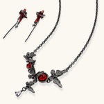 Gothic jewelry set with red resin cross pendants wrapped in dark metal chains on cream background.