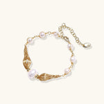 Adjustable gold bracelet with freshwater pearls and textured filigree beads on white background, showing clasp detail.