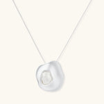 Sculptural silver necklace with flowing organic pendant featuring centered baroque pearl on white background.