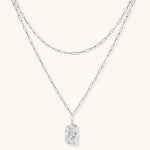 Silver layered necklace with organic flowing pendant in eco-zinc alloy on neutral background, showing adjustable chain design.