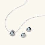 White gold plated spherical jewelry set with zirconia crystal pavé and dark lustrous centers on neutral background.