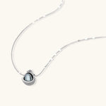 White gold plated spherical jewelry set with zirconia crystal pavé and dark lustrous centers on neutral background.