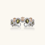Adjustable copper ring with platinum plating, featuring alternating peach and green zirconia stones in organic wave pattern