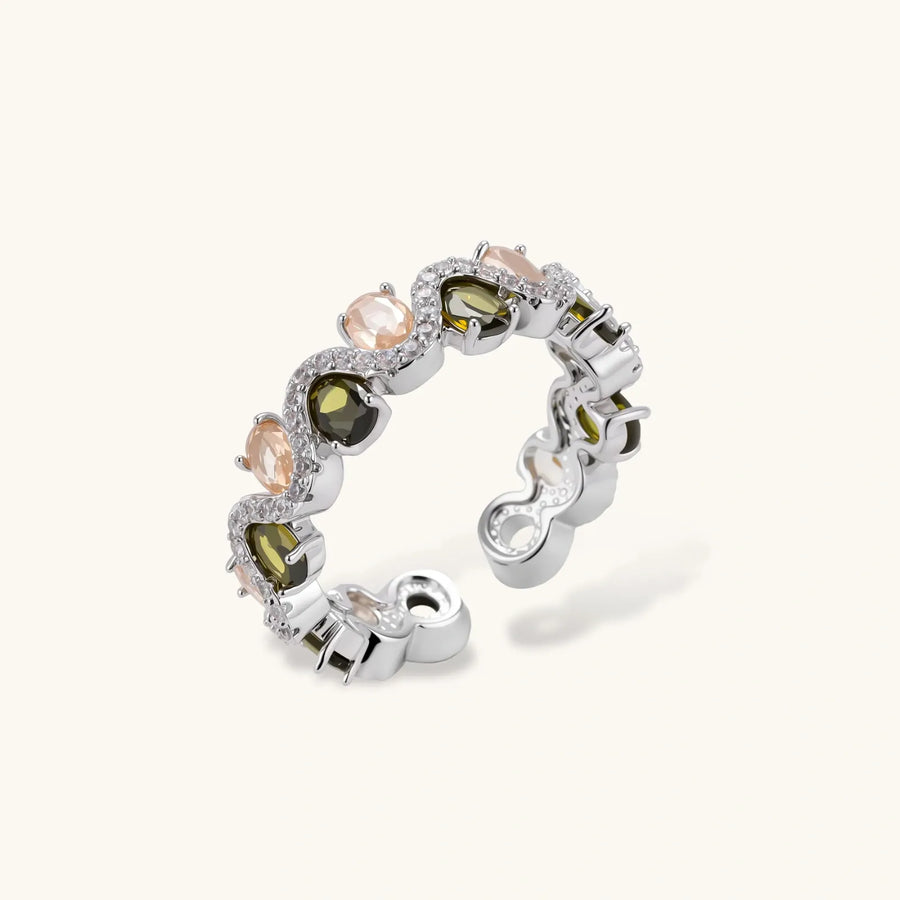Adjustable copper ring with platinum plating, featuring alternating peach and green zirconia stones in organic wave pattern