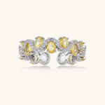 Close-up of an adjustable ring with golden zirconia stones in oval settings and clear accent stones on white gold-plated band.