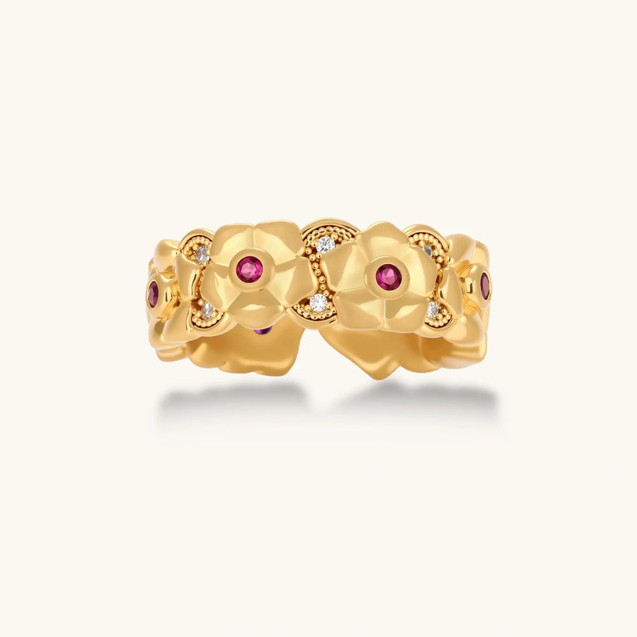 Adjustable gold-plated ring with burgundy zirconia centered flowers and crystal accents on cream background.