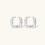 Close-up of ridged silver-plated hoop earrings with embedded crystal details on white background.